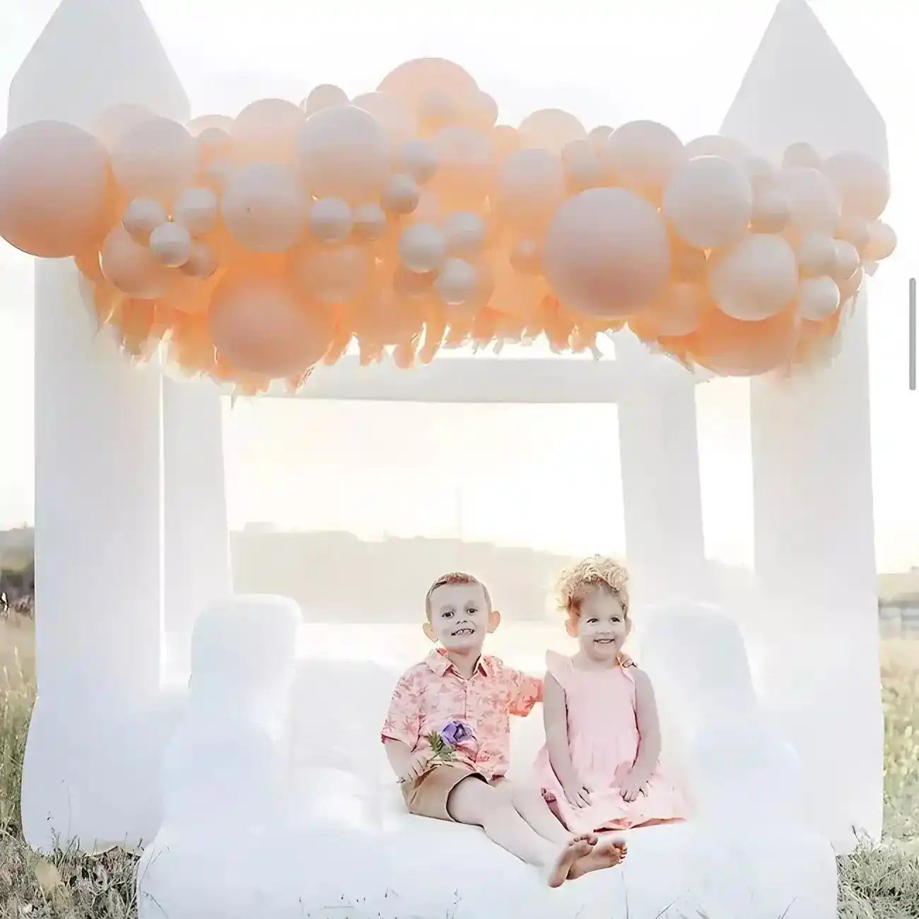 Happy kids on The Little Bounce, white small bounce house, with balloon decorations