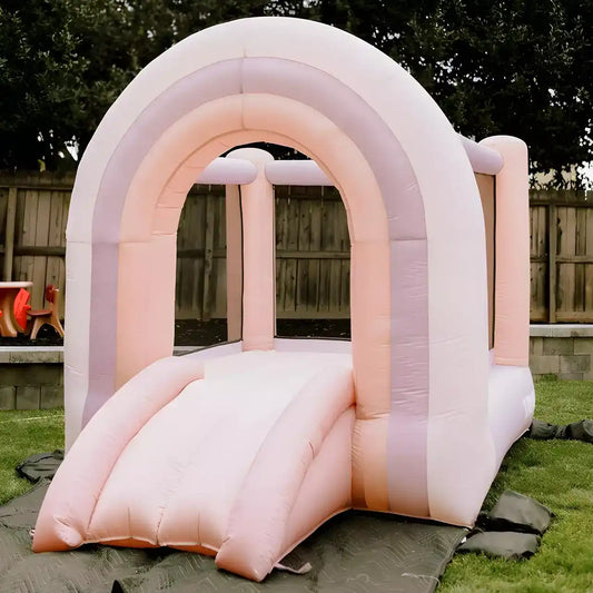 Pastel pink bounce house with rainbow arch