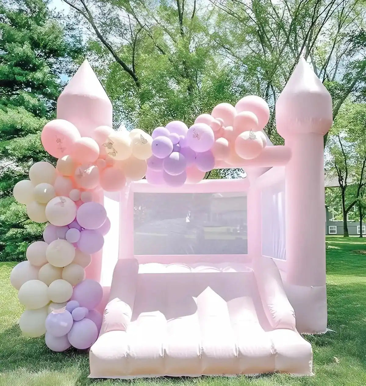 The Pastel Little Bounce, a pink mini bounce house, decorated with balloons in an outdoor park